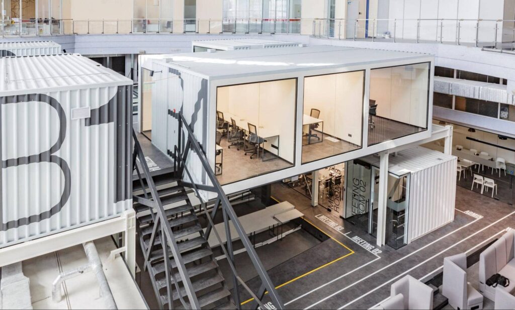 duży obiekt biurowy o otwartej strukturze zbudowany z kontenerów